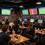 Kết quả bóng đá displayed on multiple screens in an energetic sports betting lounge