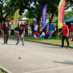 Pemain petanque di lapangan fopikotakendari.org dalam suasana bersahabat, dengan sorakan penonton di sekitar.